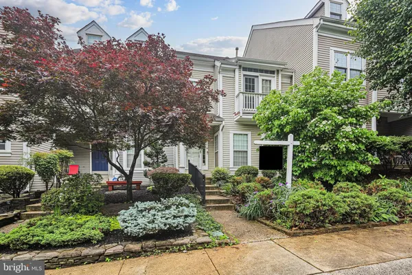 a front view of a house with a yard and potted plants