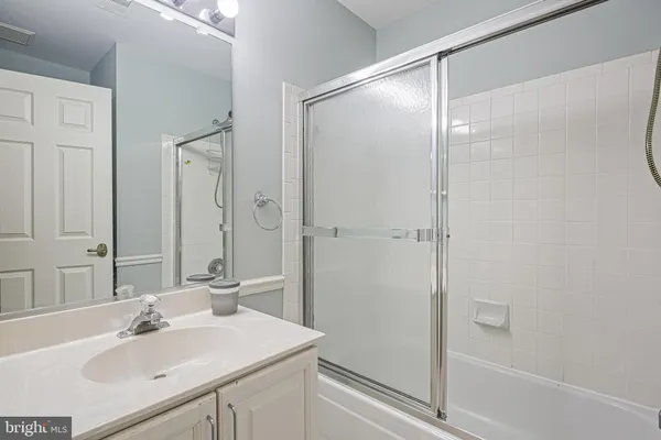 a bathroom with a sink mirror and shower