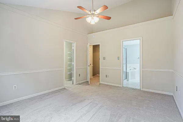 an empty room with closet and a chandelier fan