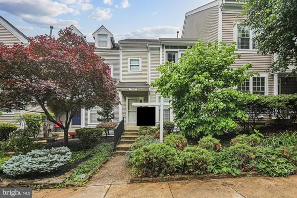front view of a house with a yard and potted plants