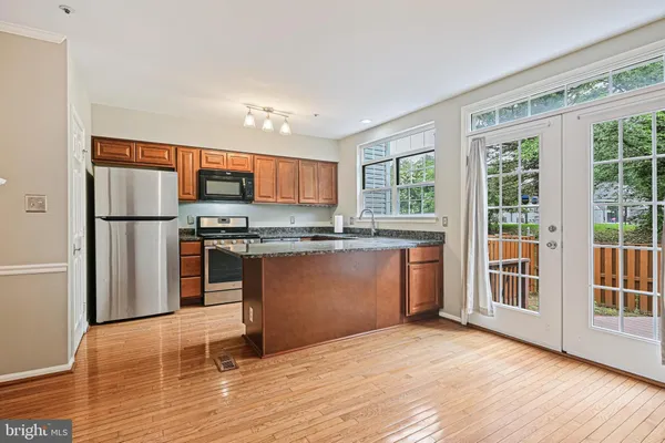 a kitchen with stainless steel appliances granite countertop a refrigerator and a stove top oven