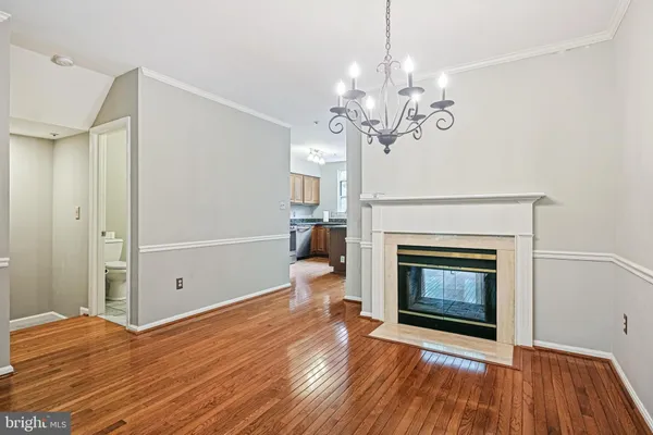 a view of a livingroom with a fireplace wooden floor and a chandelier