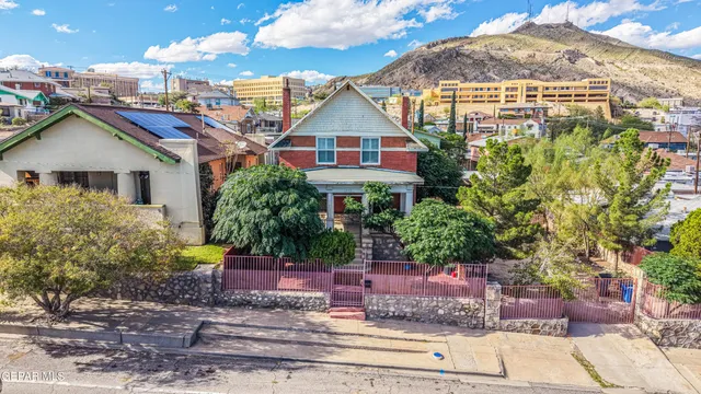 a view of a house with a yard and potted plants