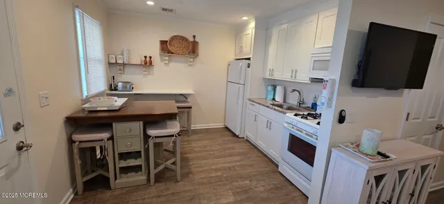 a kitchen with stainless steel appliances kitchen island granite countertop a stove a refrigerator and a microwave with wooden floor