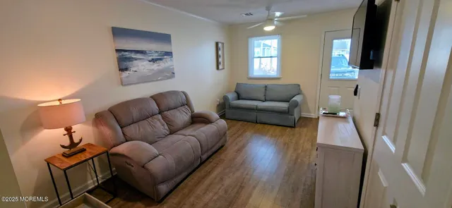 a living room with furniture and a wooden floor