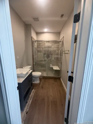 a bathroom with a sink a toilet and shower