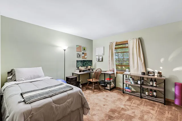 a bedroom with furniture and a large window