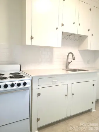 a white stove top oven sitting inside of a kitchen