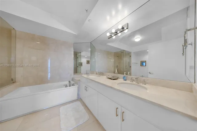a spacious bathroom with a bathtub a double vanity sink and a mirror