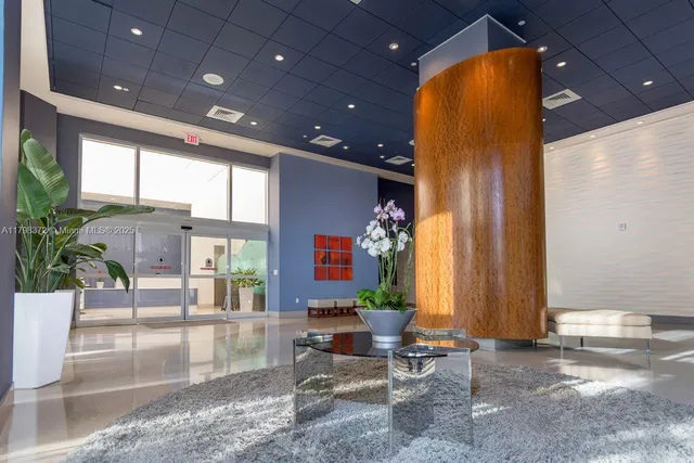 a living room with a large window and furniture