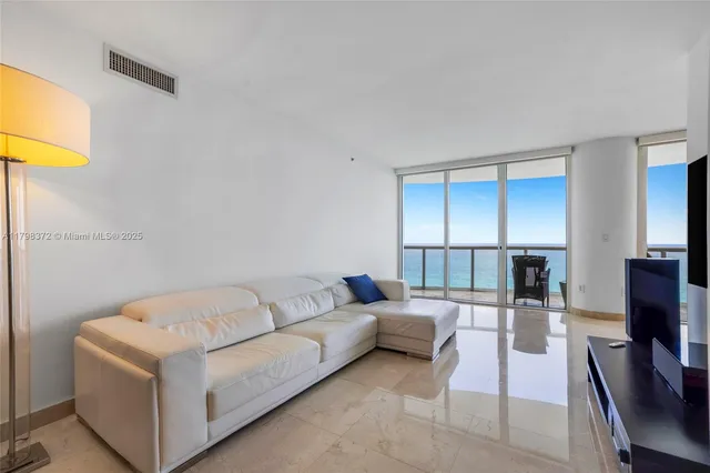 a living room with furniture a flat screen tv and a table