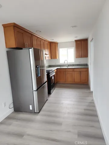 a kitchen with granite countertop a refrigerator and a sink