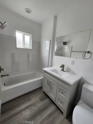a bathroom with a tub sink and mirror