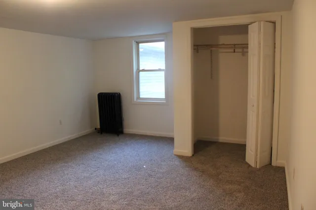 an empty room with windows and closet