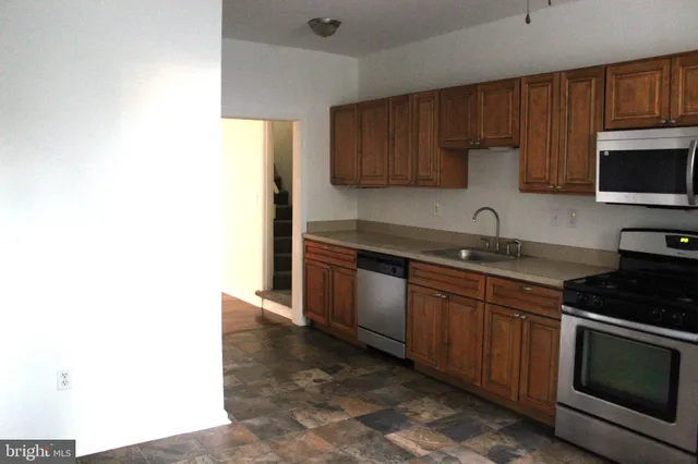 a kitchen with stainless steel appliances granite countertop a sink and a stove top oven