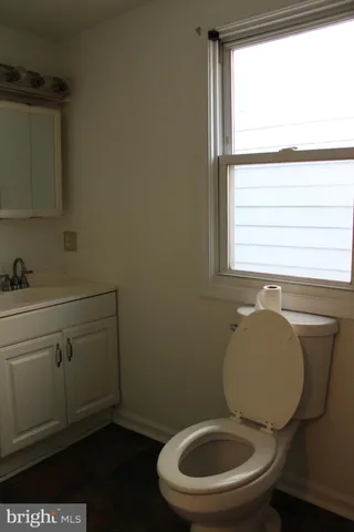 a bathroom with a toilet a sink and a window