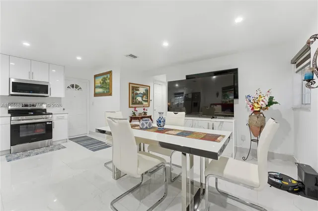 a kitchen with a table chairs refrigerator and microwave