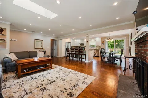 a living room with furniture a wooden floor and next to a window