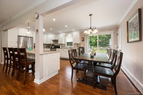a dining room with furniture a chandelier and wooden floor