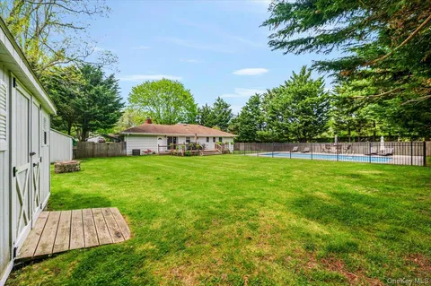 a view of yard with green space and trees in the background