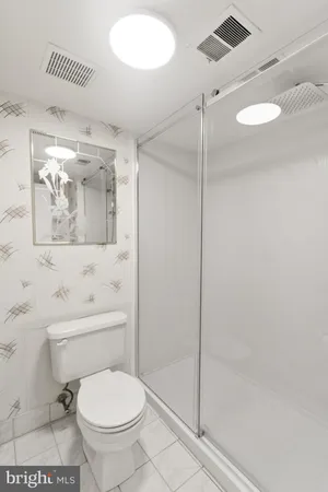 a bathroom with a toilet and a shower