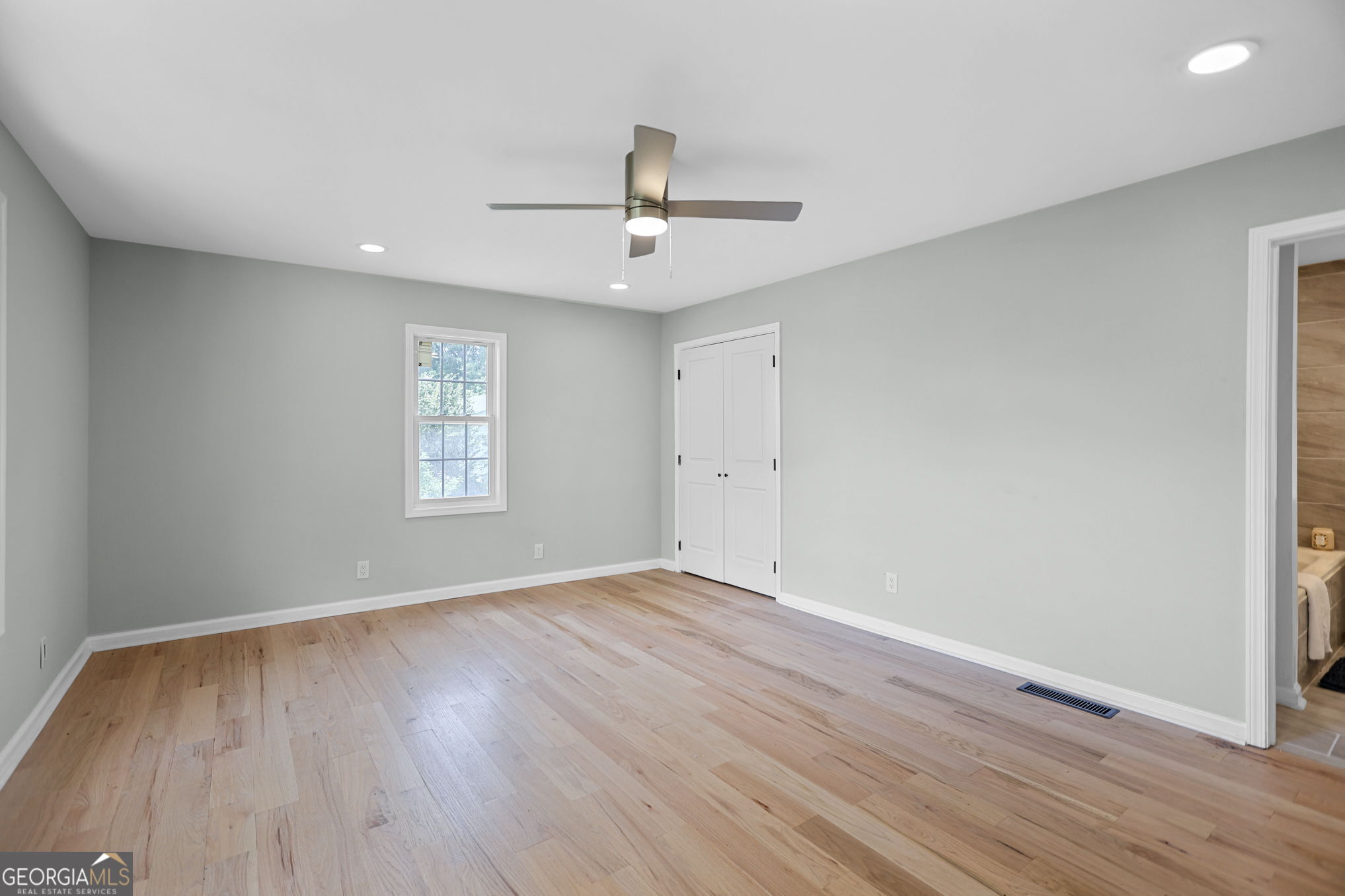 7060 Scenic Heights Road Manchester, GA 31816 - Photo 34 of 52 an empty room with wooden floor ceiling fan and windows