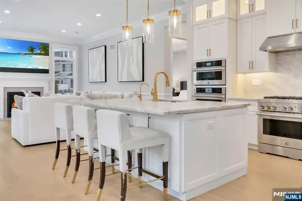 a kitchen with stainless steel appliances granite countertop a white cabinets and a stove top oven