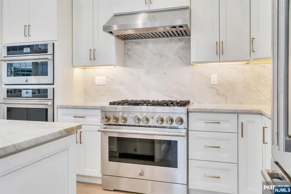 a stove top oven sitting inside of a kitchen