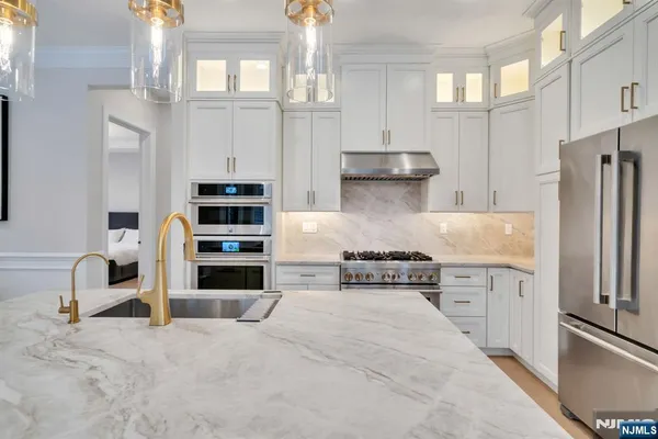 a kitchen with stainless steel appliances kitchen island granite countertop a refrigerator and a stove