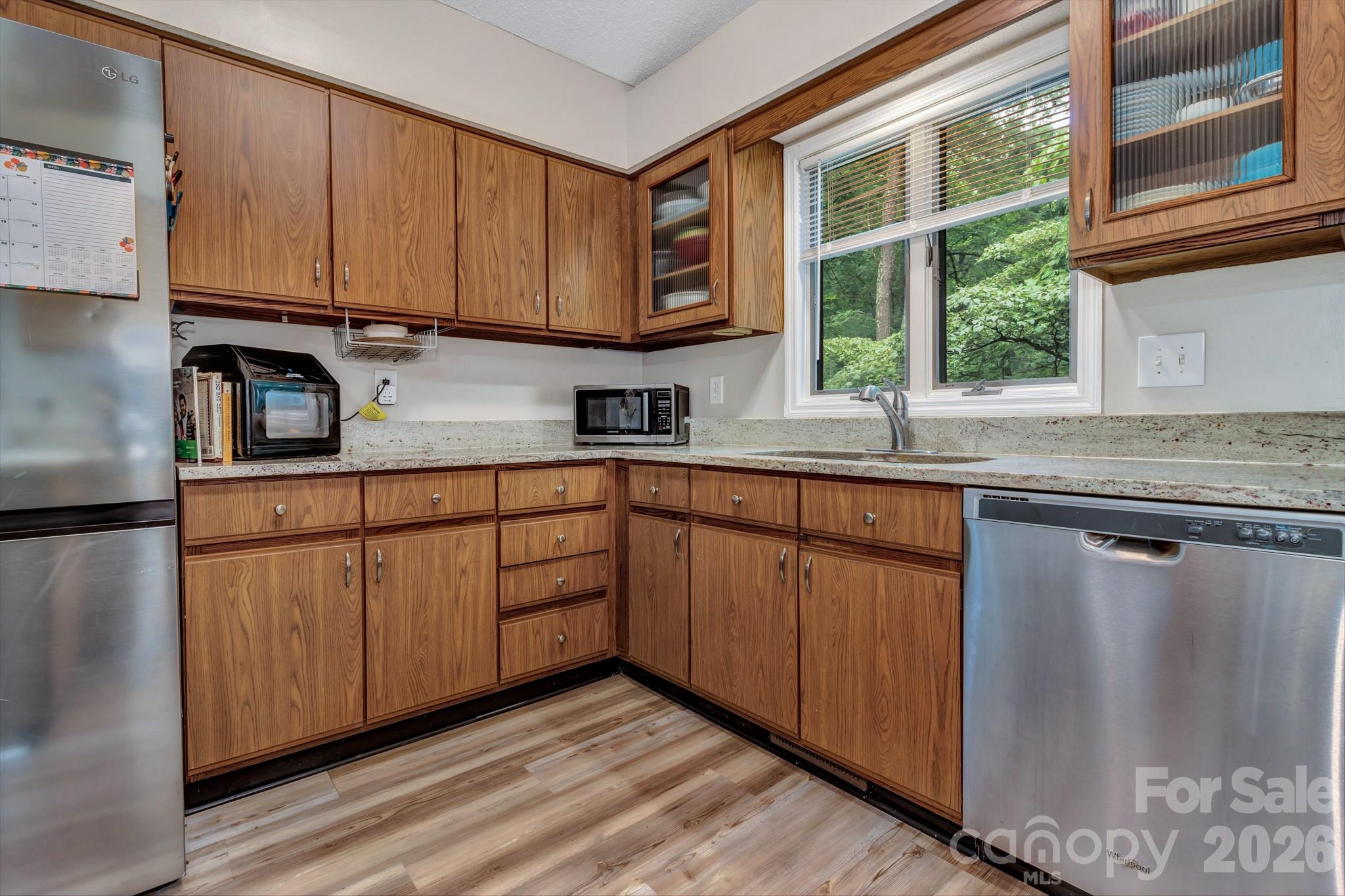 603 Rose Hill Road Asheville, NC 28803 - Photo 23 of 43 a kitchen with stainless steel appliances granite countertop a sink and cabinets with wooden floor