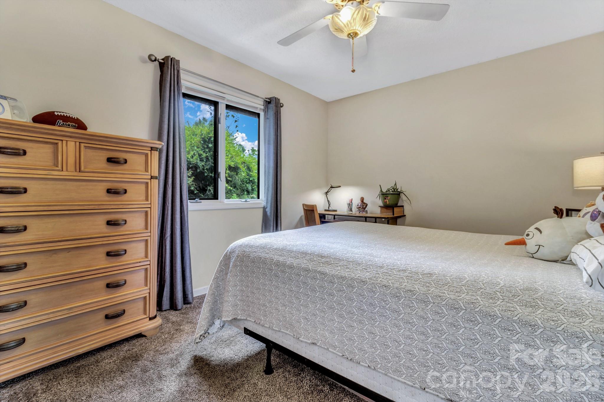 603 Rose Hill Road Asheville, NC 28803 - Photo 33 of 43 a bedroom with a bed and a chandelier