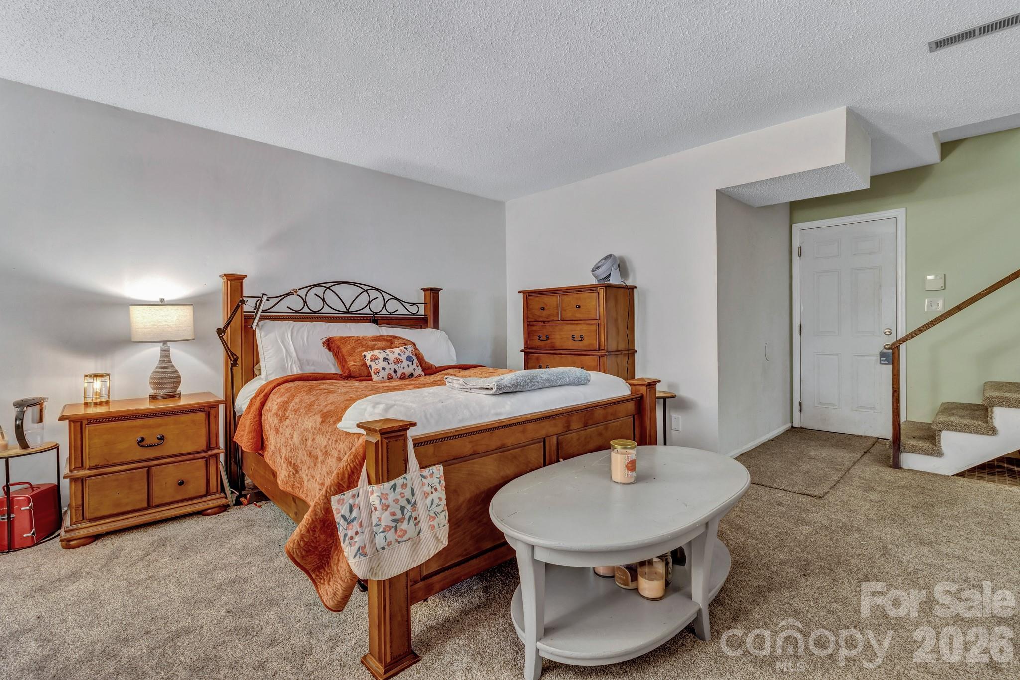 603 Rose Hill Road Asheville, NC 28803 - Photo 40 of 43 a bedroom with a bed a mirror and lamp