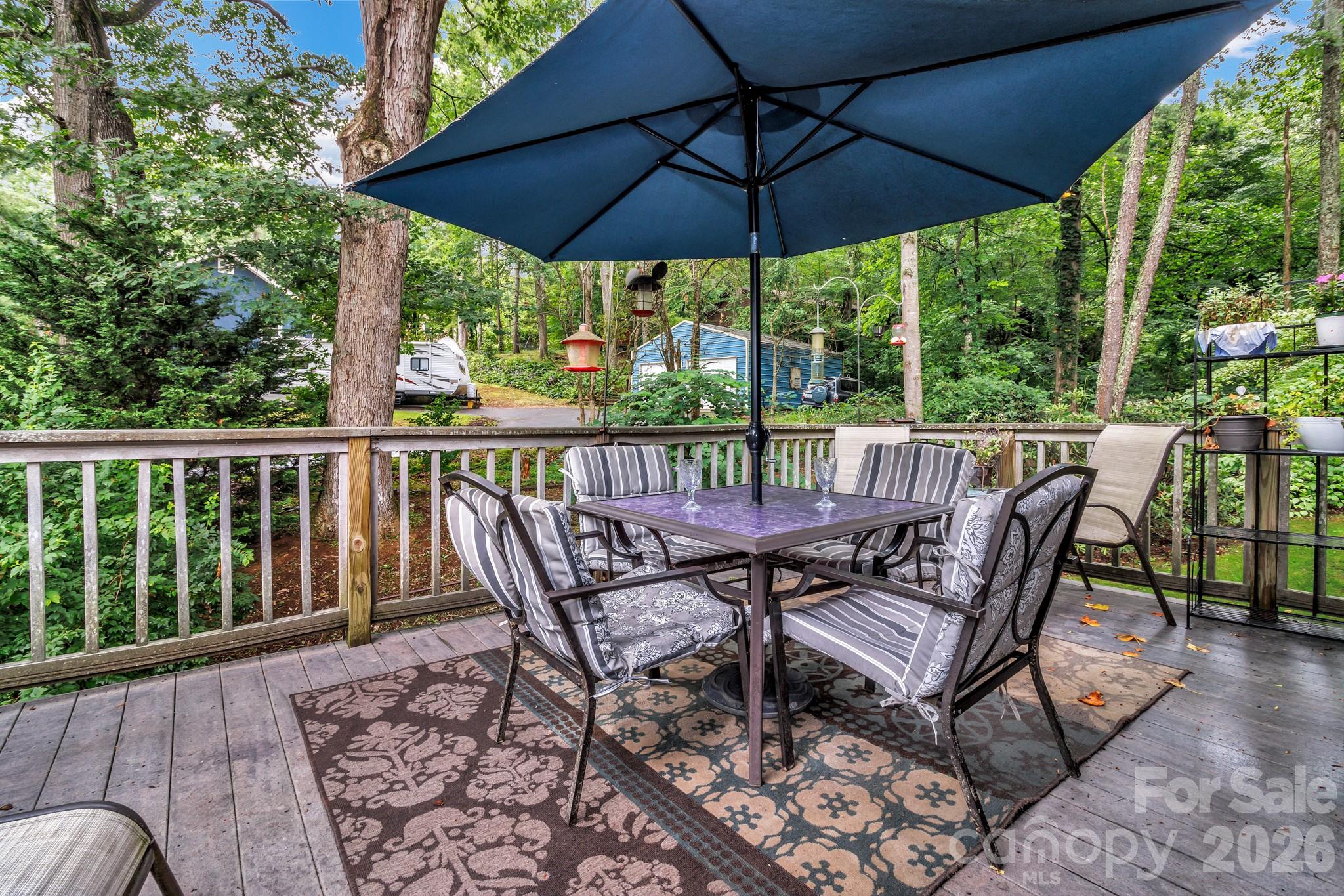 603 Rose Hill Road Asheville, NC 28803 - Photo 41 of 43 a view of a patio on the deck that has a table and chairs under an umbrella
