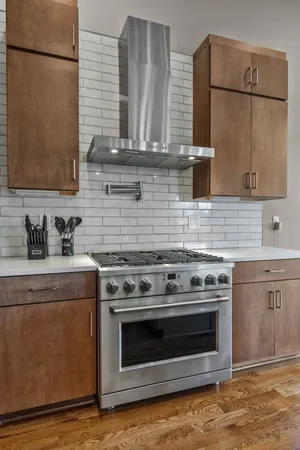 a room with stainless steel appliances kitchen island granite countertop a sink and cabinets