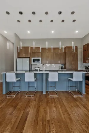 a kitchen with kitchen island granite countertop wooden cabinets and a refrigerator