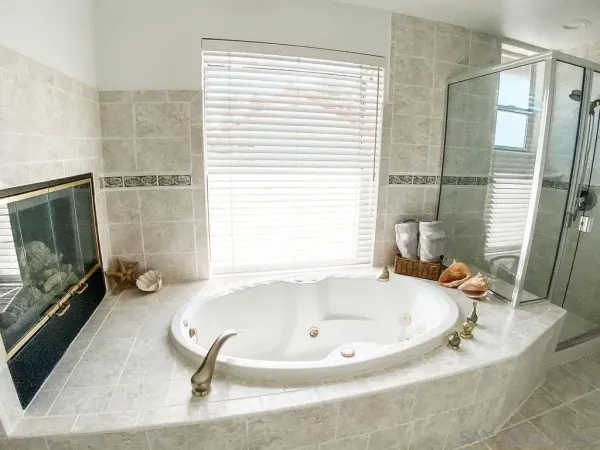 a bathroom with a tub a mirror and a sink