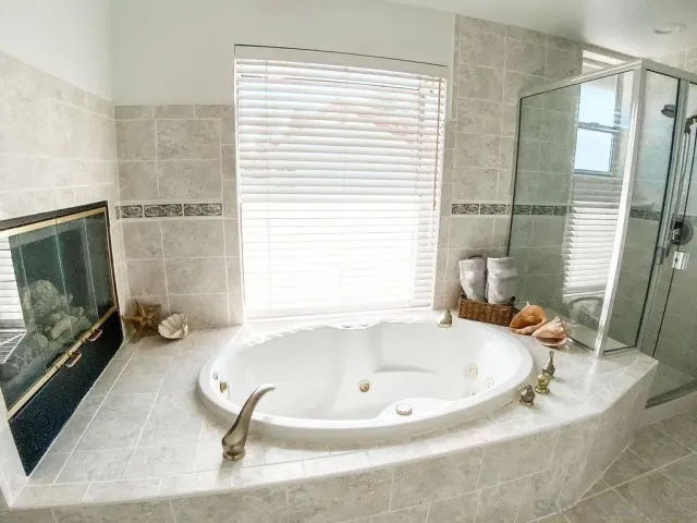 a bathroom with a tub a mirror and a sink