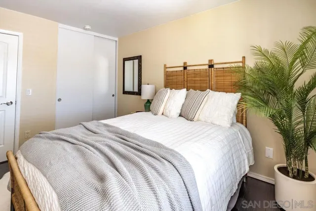 a bedroom with a bed and a potted plant