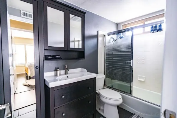 a bathroom with a sink a toilet and shower