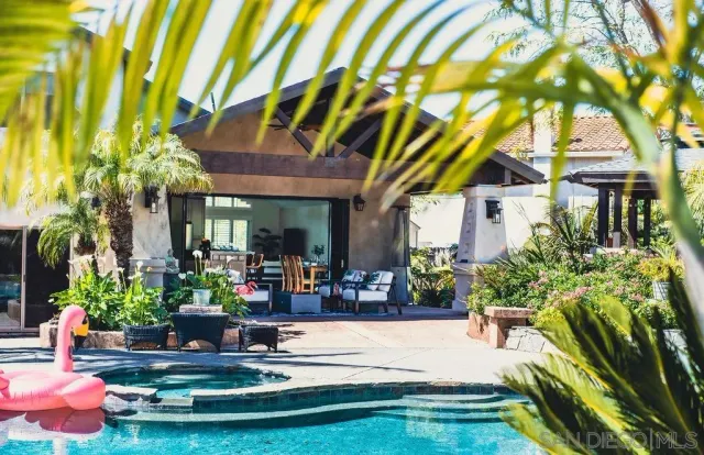 a view of a house with swimming pool and sitting area