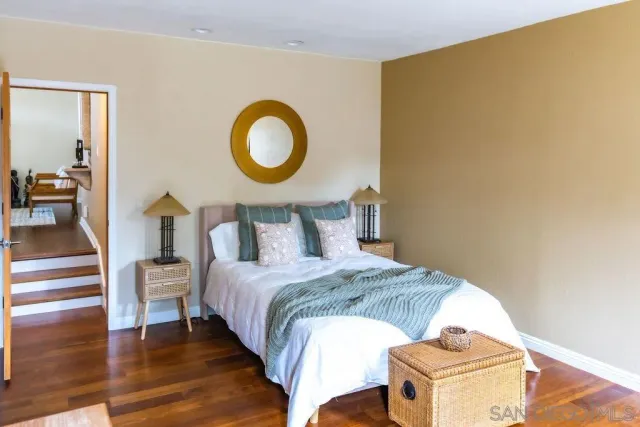 a bedroom with a bed and a painting on the wall