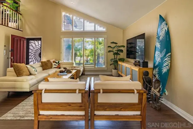 a living room with furniture a flat screen tv and a large window