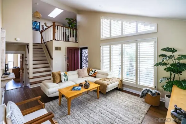 a living room with furniture floor to ceiling window and wooden floor