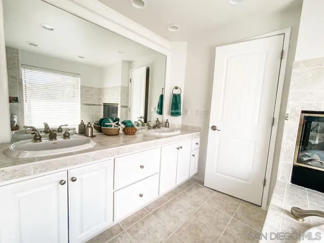 a spacious bathroom with a double vanity sink and a mirror