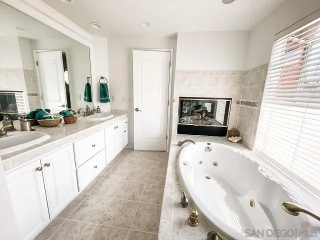 a large bathroom with a tub sink and mirror
