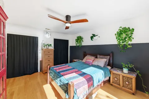 a bedroom with a bed and a potted plant