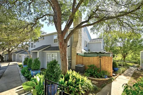 a view of a yard with wooden fence and large trees