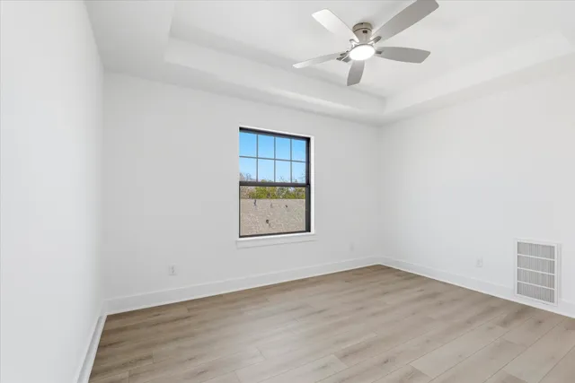 an empty room with a window and a ceiling fan