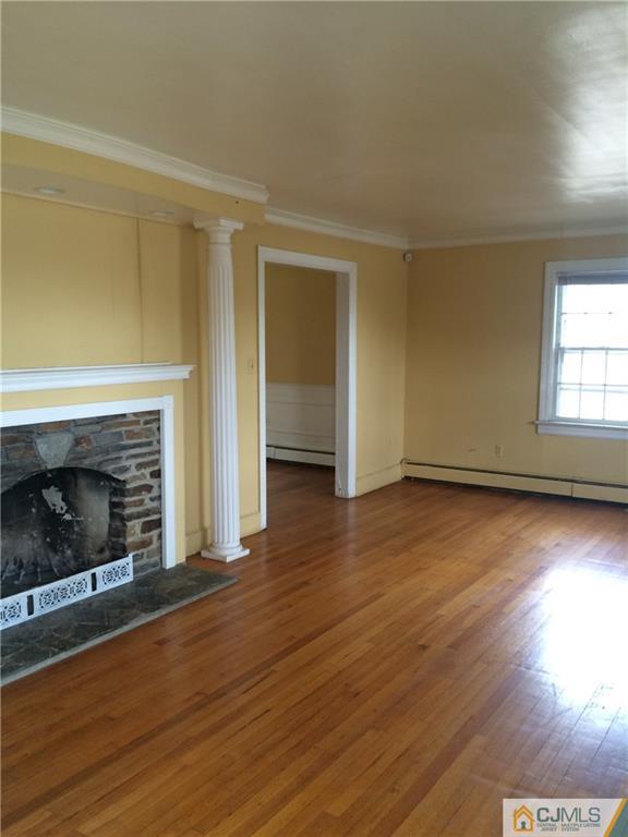 95 Westons Mill Road East Brunswick, NJ 08816 - Photo 2 of 22 an empty room with wooden floor fireplace and windows
