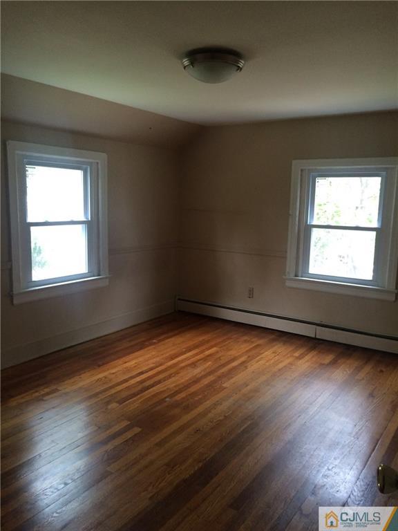 95 Westons Mill Road East Brunswick, NJ 08816 - Photo 8 of 22 an empty room with wooden floor and windows